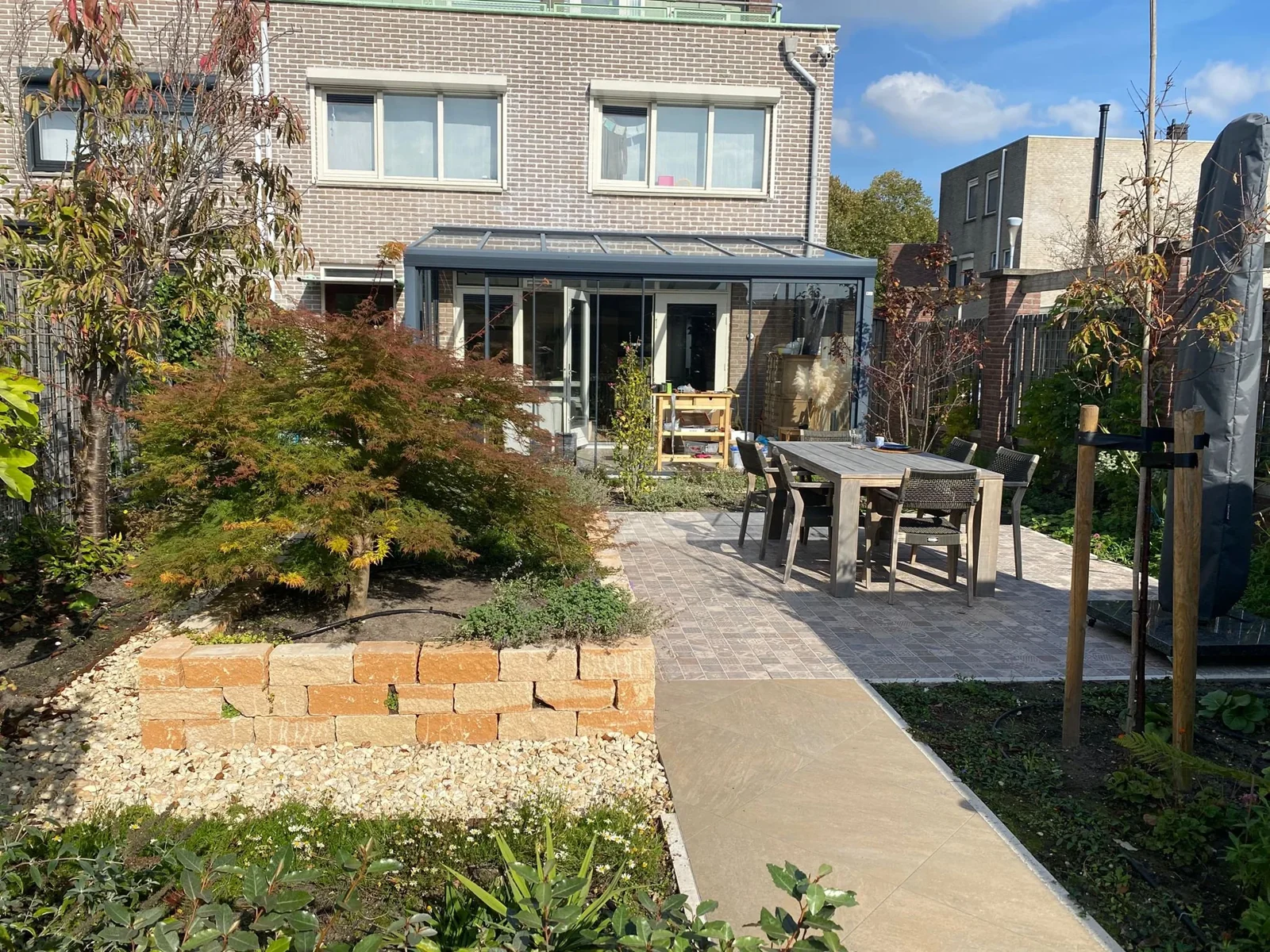 Mediterrane tuin in Hoofddorp met terras, verhoogde border en jonge bomen