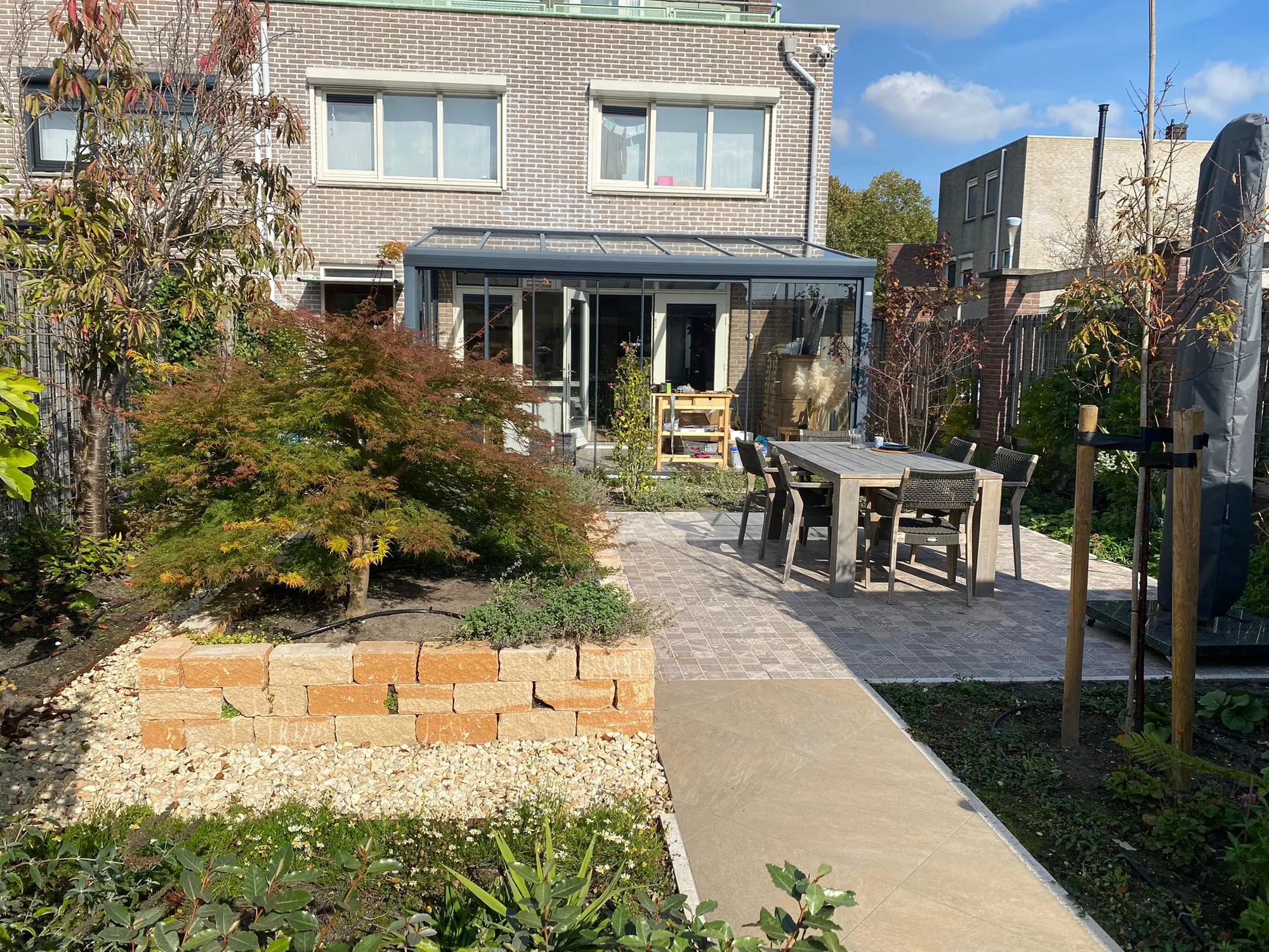 Mediterrane tuin in Hoofddorp met terras, verhoogde border en jonge bomen