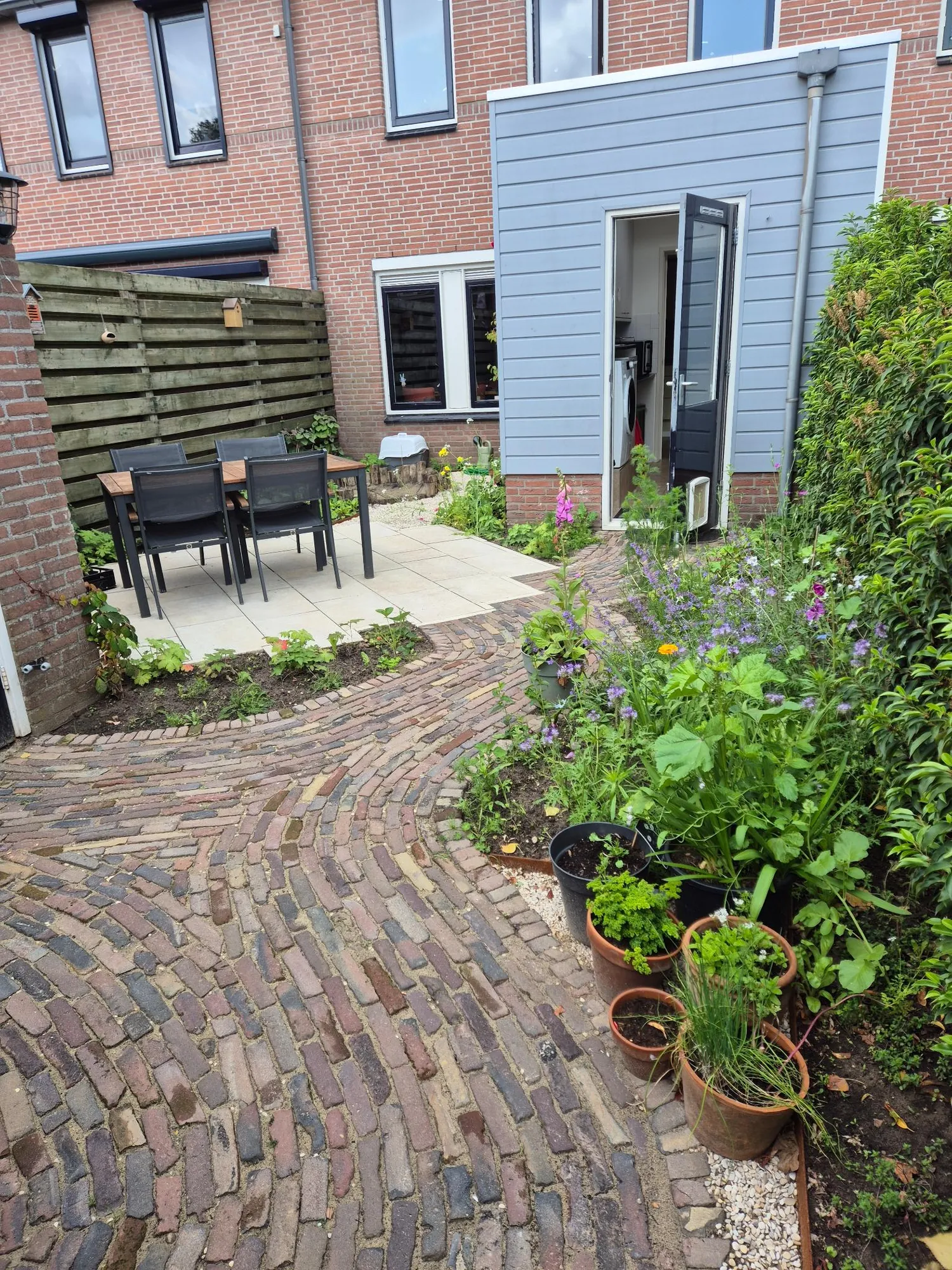 Pad van hergebruikte waaltjes naar het terras in een gezinstuin in Warnsveld